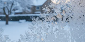 Frosty window pane with snow outside, representing cold weather payment support.